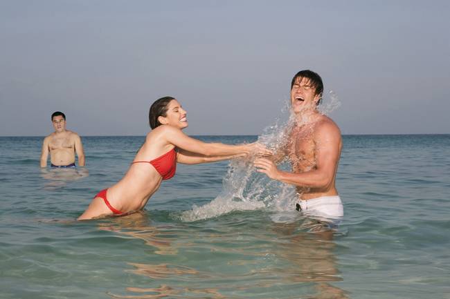 Asia, Thailand, Young Couple in ocean, splashing water